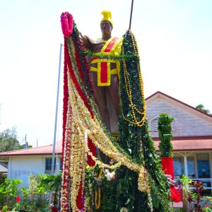 King Kamehamea Statue in Hawi adorned with colorful leis in green, red, yellow, and orange