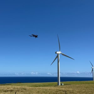 Shot of drone flying near a 60' high windmills overlooking the pacific ocean in Kohala, Hawaii