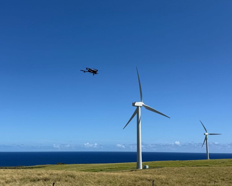 Shot of drone flying near a 60' high windmills overlooking the pacific ocean in Kohala, Hawaii